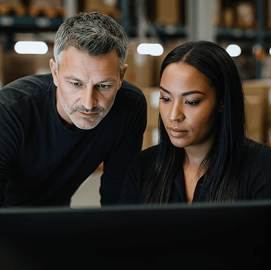 Two colleagues reviewing a shipment on a computer screen
